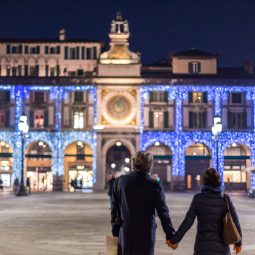 Coppia che passeggia in Piazza Loggia con luci di Natale
